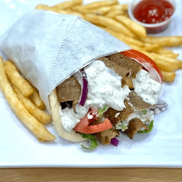 Olive Falafel's gyro sandwich with meat, vegetables, and tzatziki sauce, served with french fries and ketchup.